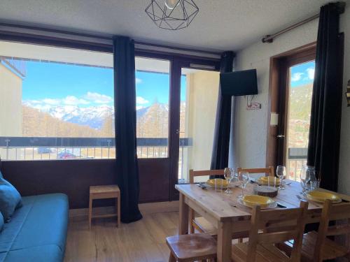 - un salon avec une table et une vue sur la montagne dans l'établissement Charmant Studio 4 Pers avec Balcons, Parking et Accès Direct aux Pistes – Montgenèvre - FR-1-330D-47, à Montgenèvre