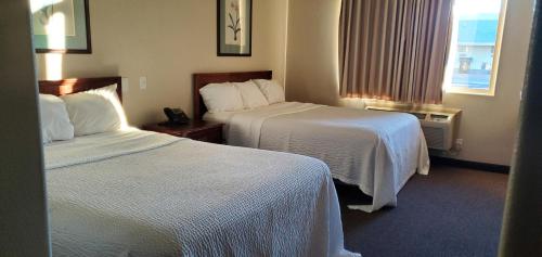a hotel room with two beds and a window at Days Inn by Wyndham Beaver in Beaver