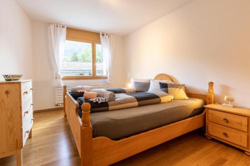 a bedroom with a wooden bed with a window at La Stüvetta in Scuol