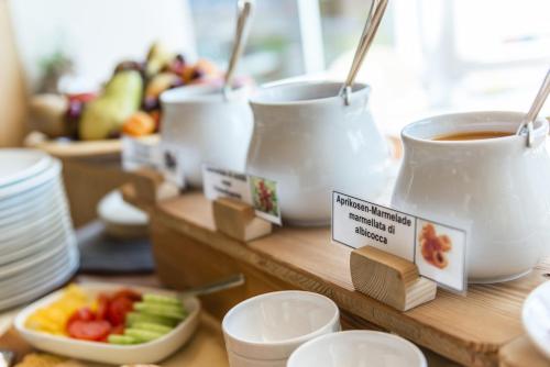een tafel met kopjes koffie en een fruitschaal bij Garni la Bercia in Selva di Val Gardena