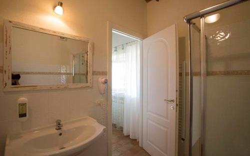 uma casa de banho com um lavatório, um chuveiro e um espelho. em Hotel Santo Stefano em Portoferraio