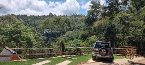a small car parked on a dirt road near a forest at QuiCupimNunCria in Miguel Pereira
