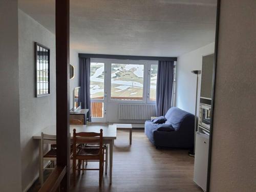 un salon avec un canapé bleu et une table dans l'établissement Joli T2 au pied des pistes, parking couvert, wifi, à La Mongie