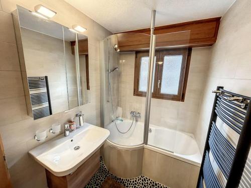 een badkamer met een wastafel, een bad, een wastafel en een spiegel bij Tzoumaz Mountain Retreat in La Tzoumaz