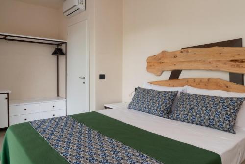 una camera con un grande letto con testiera in legno di Villa Muscì a Tortolì