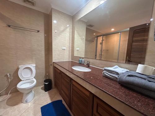 a bathroom with a toilet and a sink and a mirror at View Talay Residence 4 Jomtien 56 Sqm pool view in Jomtien Beach