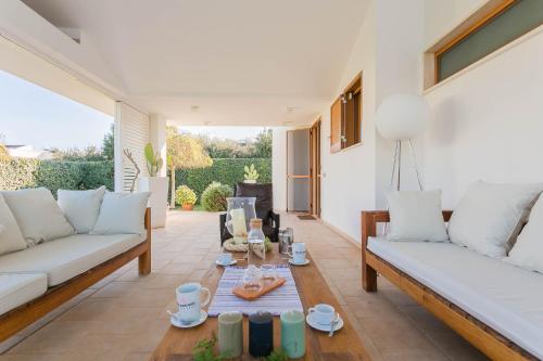 ein Wohnzimmer mit weißen Sofas und einem Tisch in der Unterkunft Villa Incanto nel Blu by Wonderful Italy in Polignano a Mare