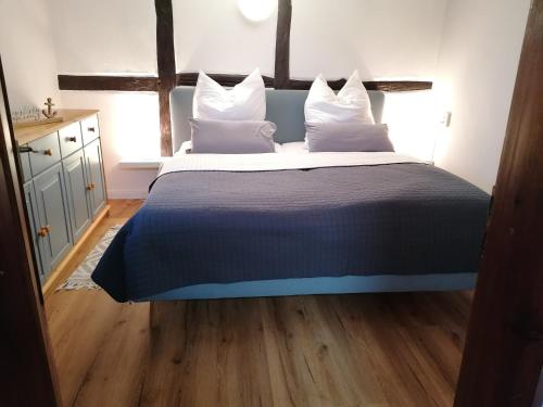 a bedroom with a large bed with white pillows at Reetmeer Apartments Spa & Reetdach am Salzhaff in Boiensdorf