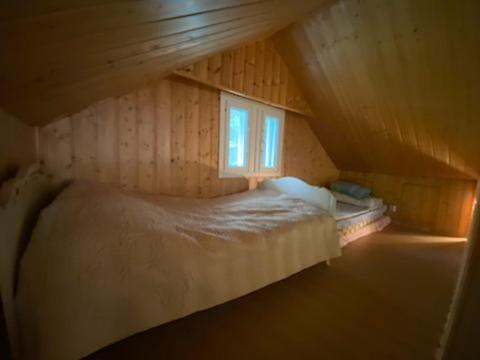Dormitorio pequeño con cama en el ático en Perälampi, en Huissi