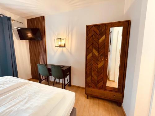 a bedroom with a bed and a mirror and a table at Gästehaus am Stadtpark in Vöcklabruck