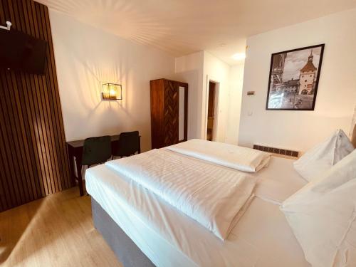a bedroom with a large white bed in a room at Gästehaus am Stadtpark in Vöcklabruck