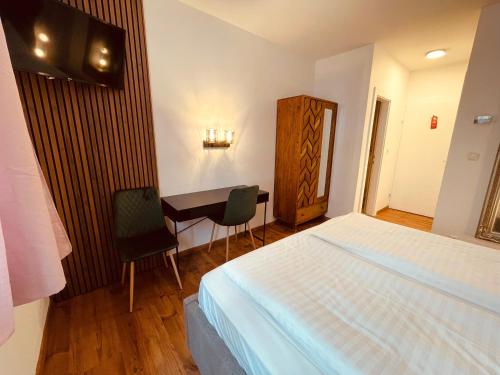 a bedroom with a bed and a table and a desk at Gästehaus am Stadtpark in Vöcklabruck