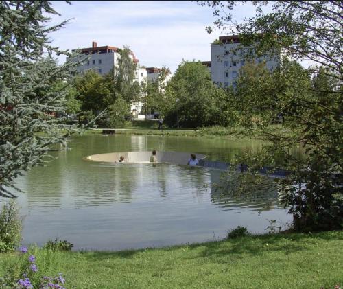 three people swimming in a pond in a city at Gästehaus am Stadtpark in Vöcklabruck