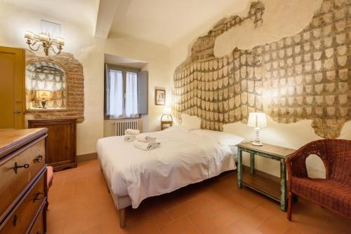 ein Schlafzimmer mit einem großen weißen Bett und einem Stuhl in der Unterkunft Casa torre via de' Nerì in Florenz