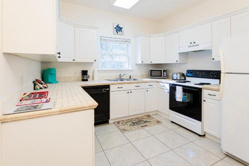 a white kitchen with white cabinets and black appliances at Private 2 bedroom and 2 bathroom in Savannah in Savannah