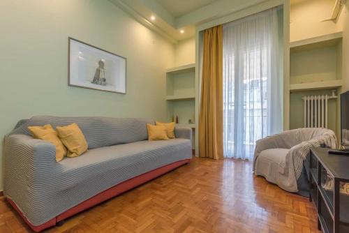 uma sala de estar com um sofá e uma janela em City Haven: 1-BR, Central Athens em Atenas