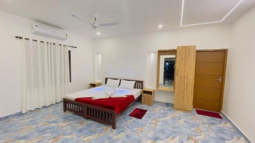 a bedroom with a large bed with a red blanket at MARARI GOD's OWN VILLA in Alleppey