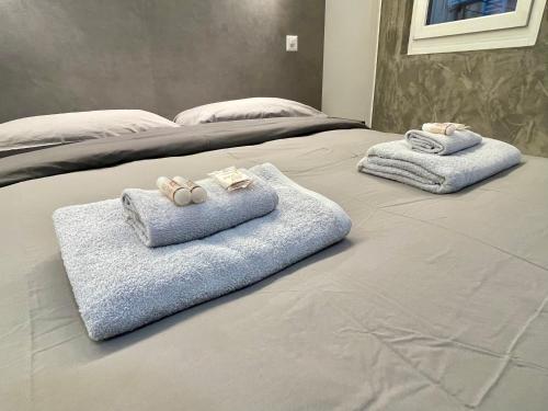 two towels on top of a bed with at TALEDA Apartments - Modern Apartments & Self Checkin in the Old Town in Lugano