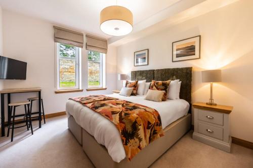 a bedroom with a bed and a desk in it at Royal Golf Apartments in Dornoch
