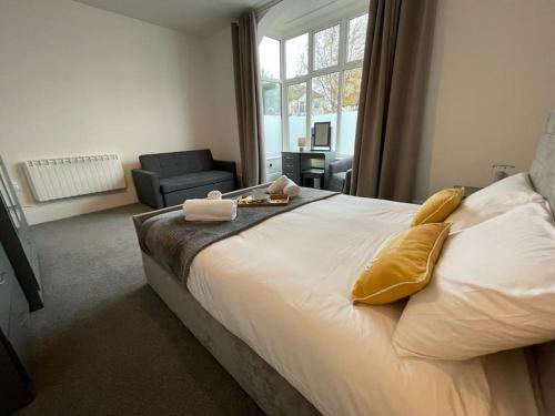 a bedroom with a large white bed with yellow pillows at Lovely Apartment in Cleethorpes (sleeps up-to 10) in Cleethorpes