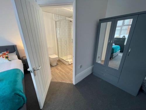 a bedroom with a bed and a bathroom with a mirror at Lovely Apartment in Cleethorpes (sleeps up-to 10) in Cleethorpes