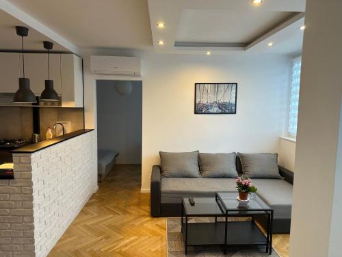Project Comfort Apartament Grzybowska 30/1211 في وارسو: غرفة معيشة مع أريكة وطاولة