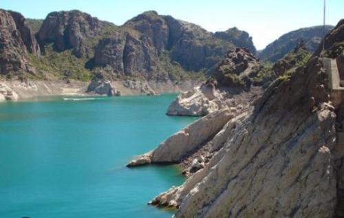 una gran masa de agua con montañas en el fondo en Departamentos San Rafael en San Rafael