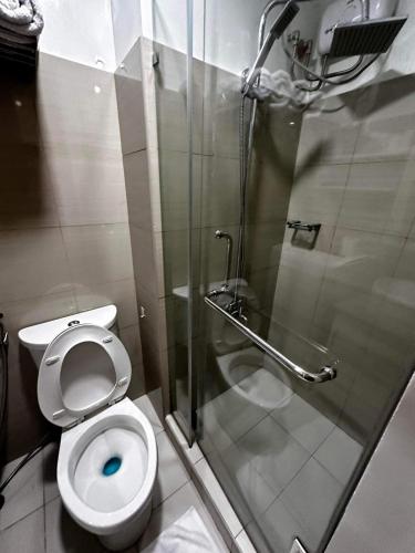 a bathroom with a toilet and a glass shower at Deluxe Suites Razelles 2 at Shore 2 Residences Tower 1 in Manila