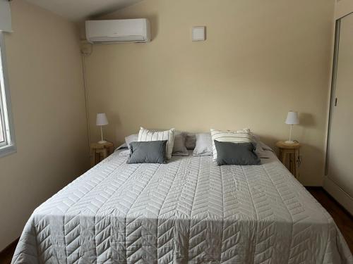 1 dormitorio con 1 cama blanca grande y 2 almohadas en Casa Cerro de las Rosas en Córdoba