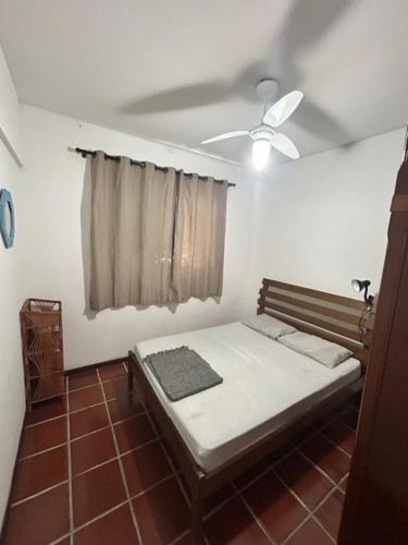 1 dormitorio con 1 cama y ventilador de techo en Apartamento Guaruja Enseada, en Guarujá