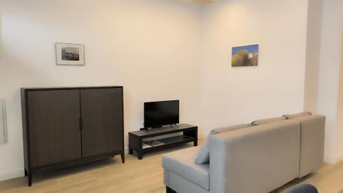 a living room with a couch and a television at Exyca Metropolitano in Madrid