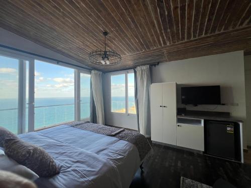 a bedroom with a bed and a tv and windows at Sea View Cabin in Alexandria