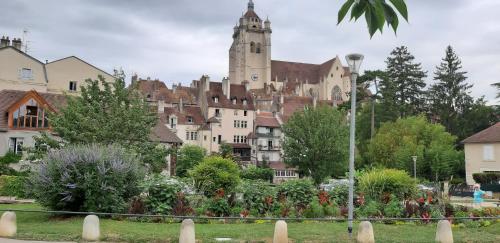 a large building with a castle in the background at maison Chez Kitoune in Éclans