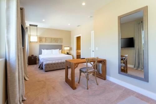 a hotel room with a bed and a table and a mirror at 4 Suites - 5 min from Disney - w Jacuzzi 7557 in Orlando