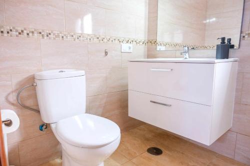 La salle de bains est pourvue de toilettes blanches et d'un lavabo. dans l'établissement Parque Santiago II 335 by Tenerife Rental and Sales, à Playa de las Americas