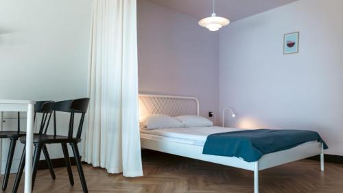 biała sypialnia z łóżkiem i stołem w obiekcie Apartments ABCD w Białej Podlaskiej