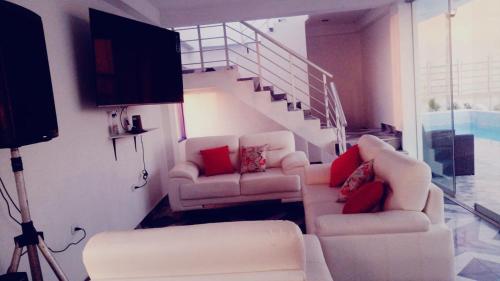 ein Wohnzimmer mit 2 Sofas und einer Treppe in der Unterkunft YAKY'S TOPARA in Jaguay
