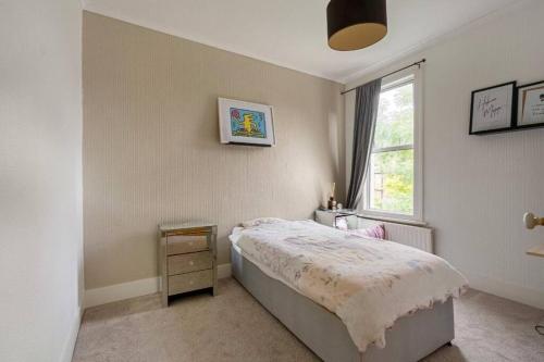 1 dormitorio con cama y ventana en Cosy tranquil semi-detach house, en Beckenham