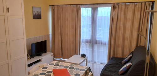 a living room with a couch and a large window at Studio Algarve in Middelkerke