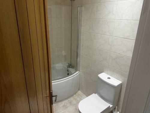 a bathroom with a toilet and a bath tub at Cosy barn conversion in the Mournes in Newry