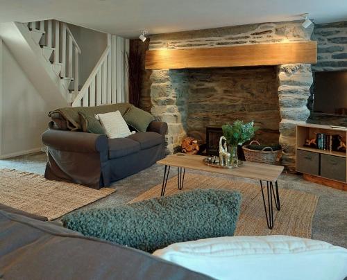 a living room with a couch and a stone fireplace at Craig View Fishermans Cottage nr Harbour and Beach in Barmouth