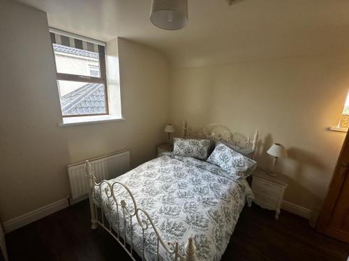a bedroom with a bed and a window at Cosy barn conversion in the Mournes in Newry