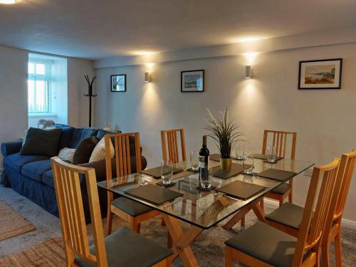 a dining room with a glass table and chairs at Craig View Fishermans Cottage nr Harbour and Beach in Barmouth