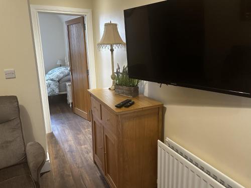a living room with a large flat screen tv on a wall at Cosy barn conversion in the Mournes in Newry