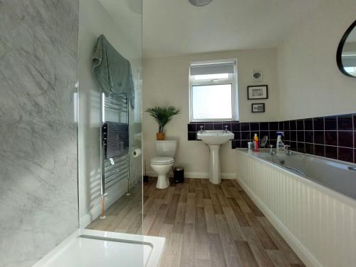 ein Badezimmer mit einer Badewanne, einem Waschbecken und einem WC in der Unterkunft Craig View Fishermans Cottage nr Harbour and Beach in Barmouth