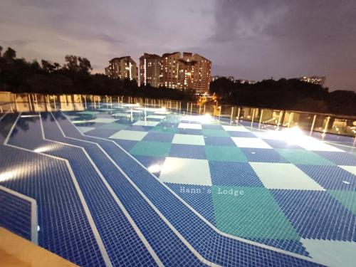 a large swimming pool at night with blue and white tiles at Hann's Lodge in Putrajaya