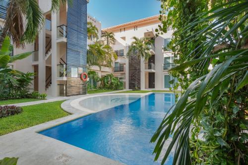 a swimming pool in front of a building at Apartment Tendenza Centro in Playa del Carmen
