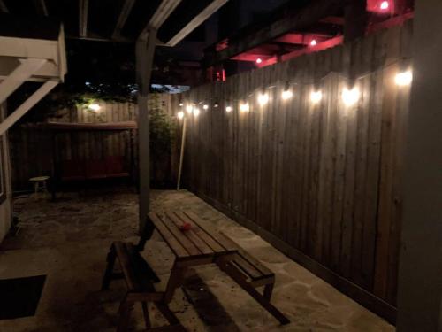 a wooden bench in front of a wooden fence at night at Stylish Studio in Montrose - The Italian Plaza in Houston