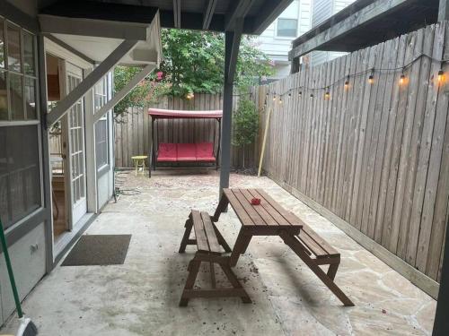 een patio met een houten tafel en een rode bank bij Stylish Studio in Montrose - The Italian Plaza in Houston
