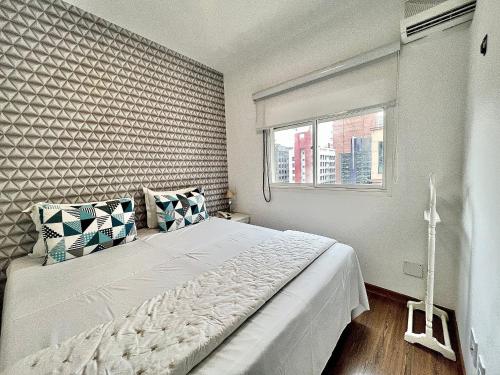 a bedroom with a large white bed with a window at Flat Funchal JK Limpeza Diária, Internet 300mb in Sao Paulo